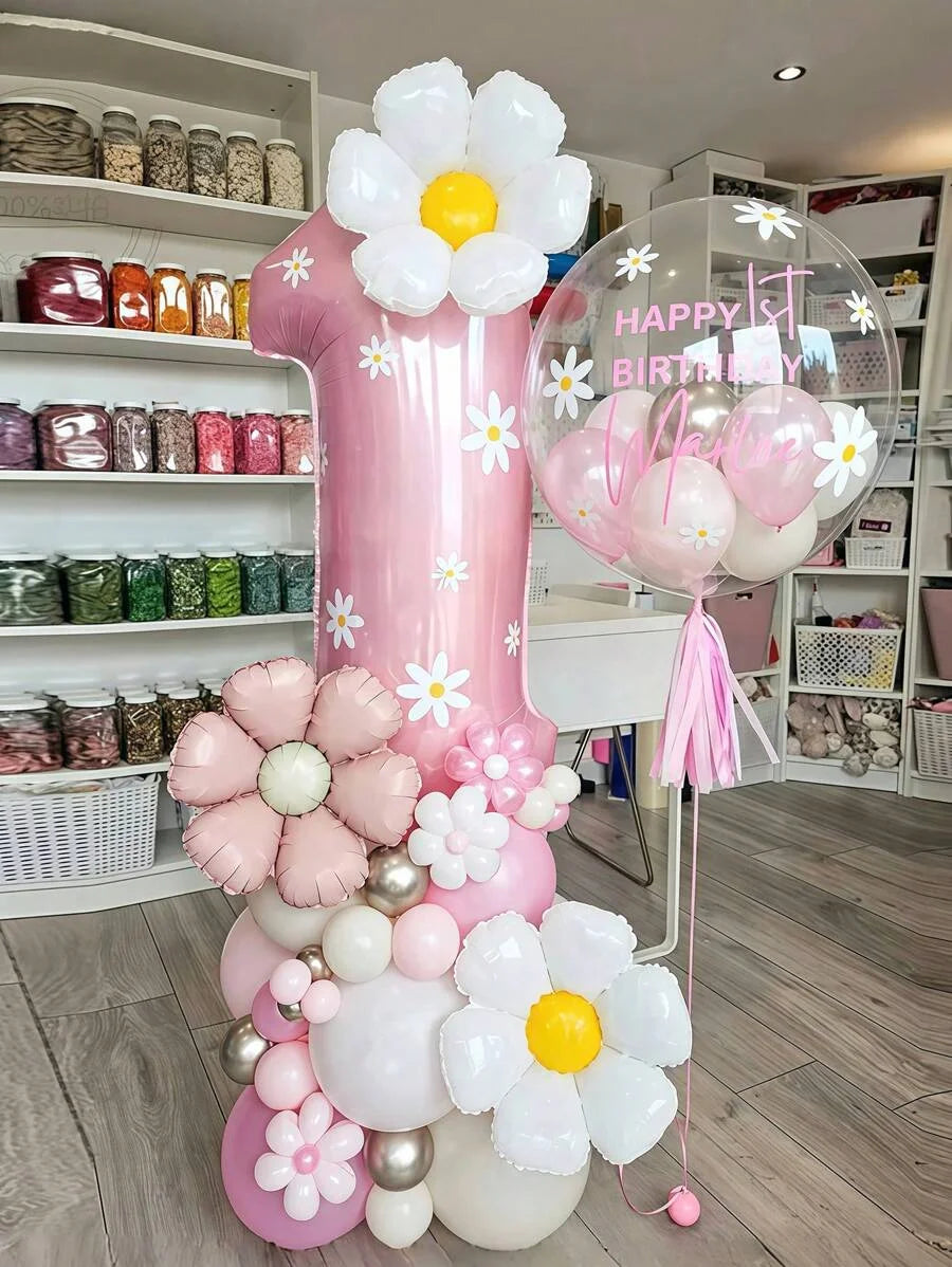 A pink pillar balloon set decorated with white and yellow flowers and stars, including a large number one balloon.