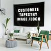 A black tapestry featuring white text that reads Customize Tapestry Image/Logo displayed in a modern living room setting.