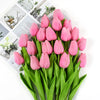 A bouquet of pink tulips with green stems and leaves displayed next to a photo collage.