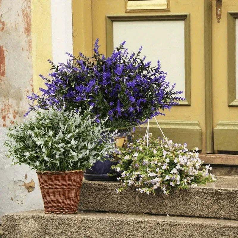 A bouquet of purple and white artificial flowers displayed on stone steps against a yellow building facade.