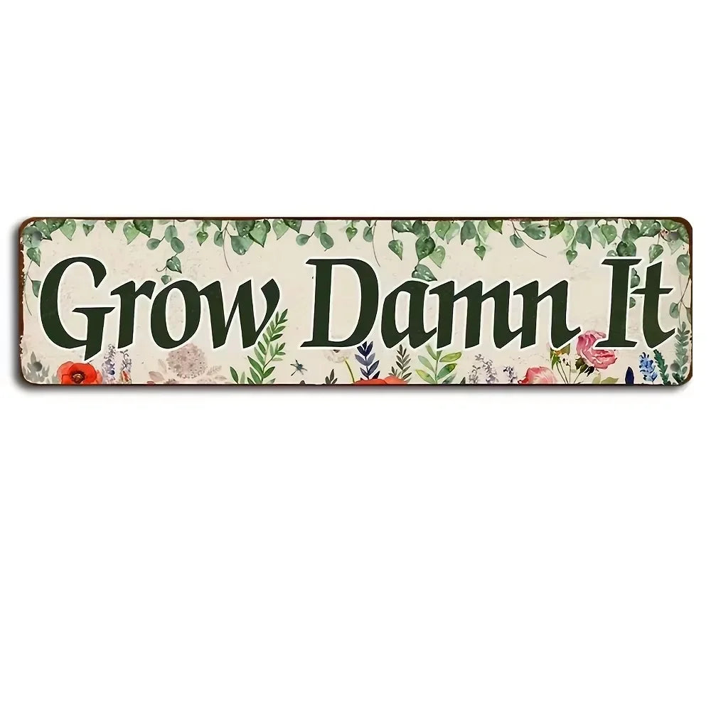 A vintage metal sign with the text Grow Damn It surrounded by green foliage and small flowers on a light background.