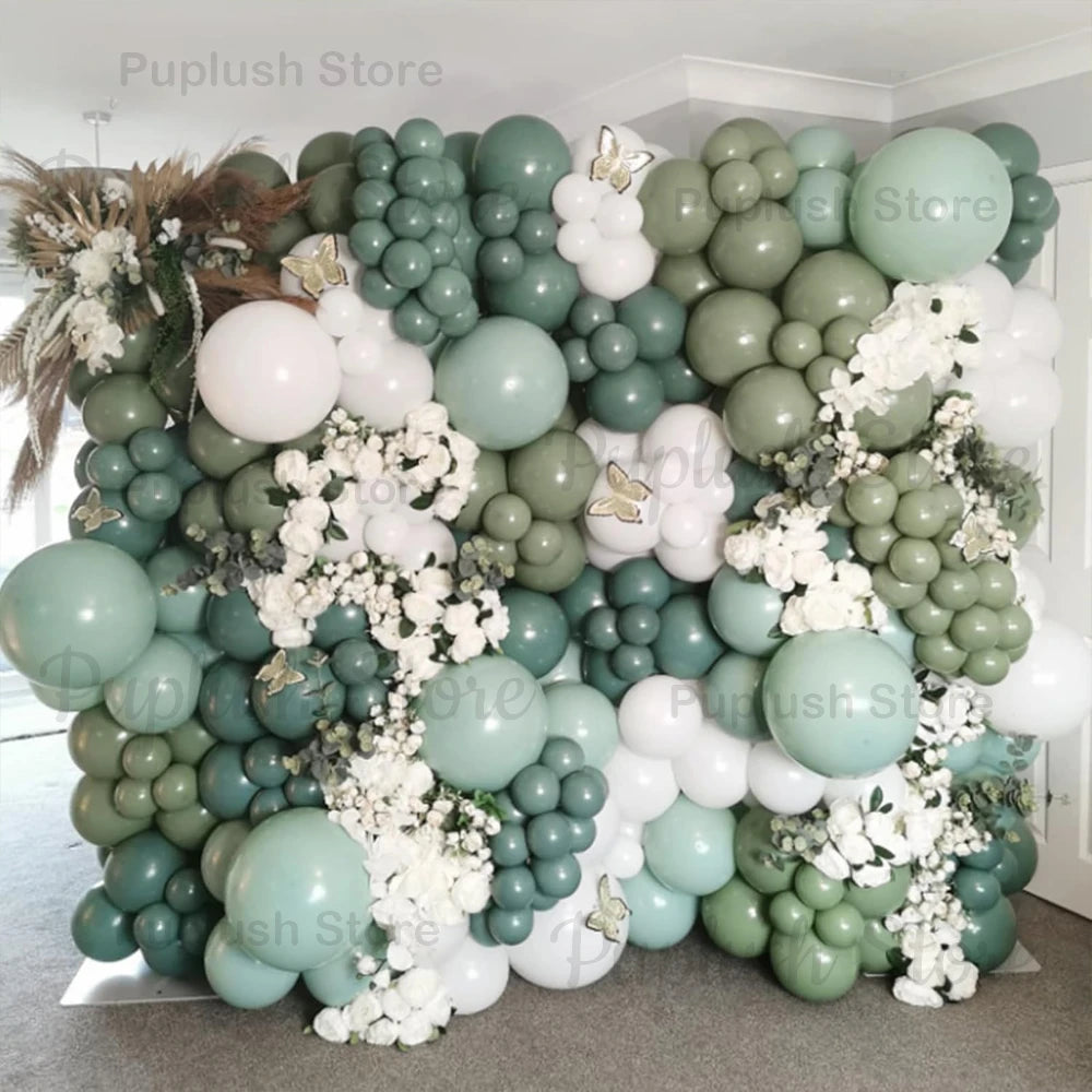 A dense arrangement of sage green and white latex balloons forming a floral backdrop for parties and events.
