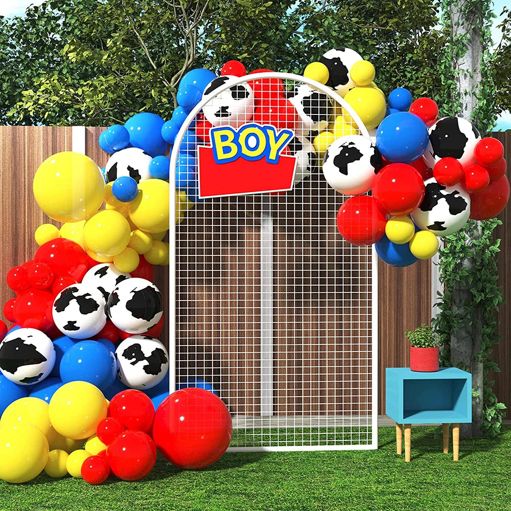 A balloon garland arch kit featuring black and white and solid colored balloons in red, yellow, and blue surrounding a wooden