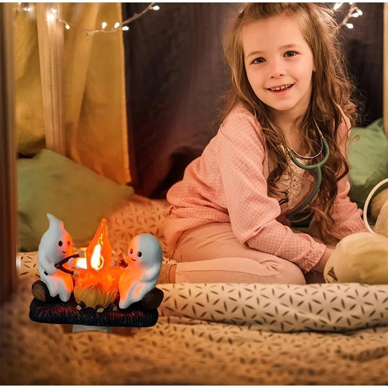 A smiling girl sits next to a glowing ghost bonfire night light with two small figures.