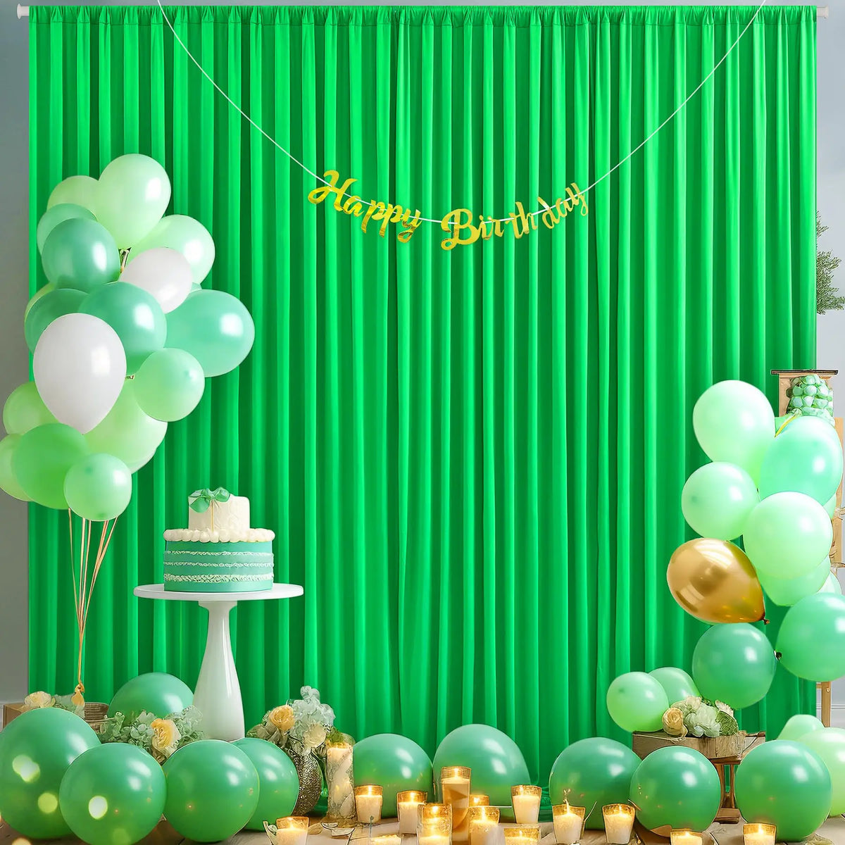A vibrant green curtain backdrop decorated with balloons, including light green and white balloons, and a golden birthday ban