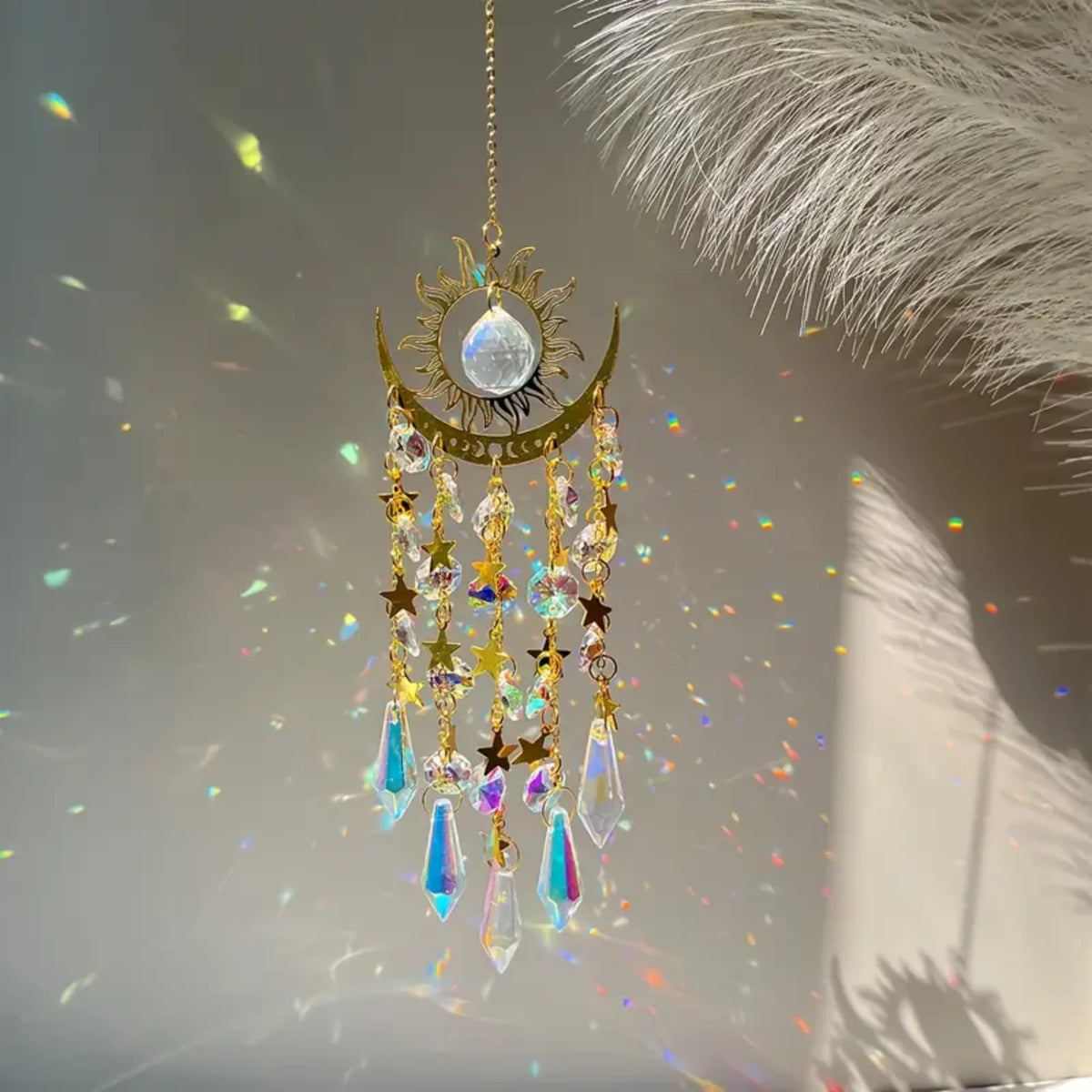 A hanging gold star moon wind chime featuring a central silver orb and dangling crystal beads.