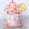 A pink princess castle cake topper set featuring a castle, stars, and a golden birthday banner on a tiered cake.