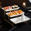 An elegant three-tier serving rack displaying sushi and fried seafood on a black tablecloth.