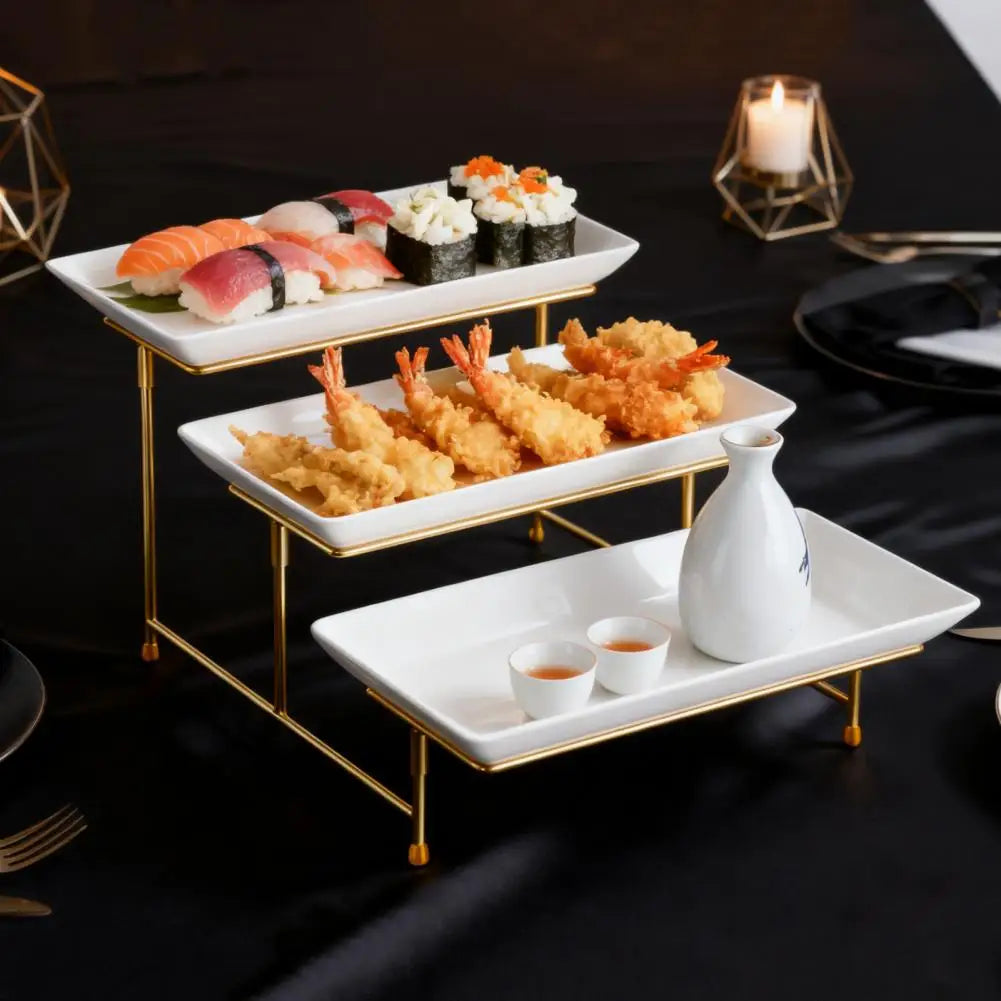 An elegant three-tier serving rack displaying sushi and fried seafood on a black tablecloth.