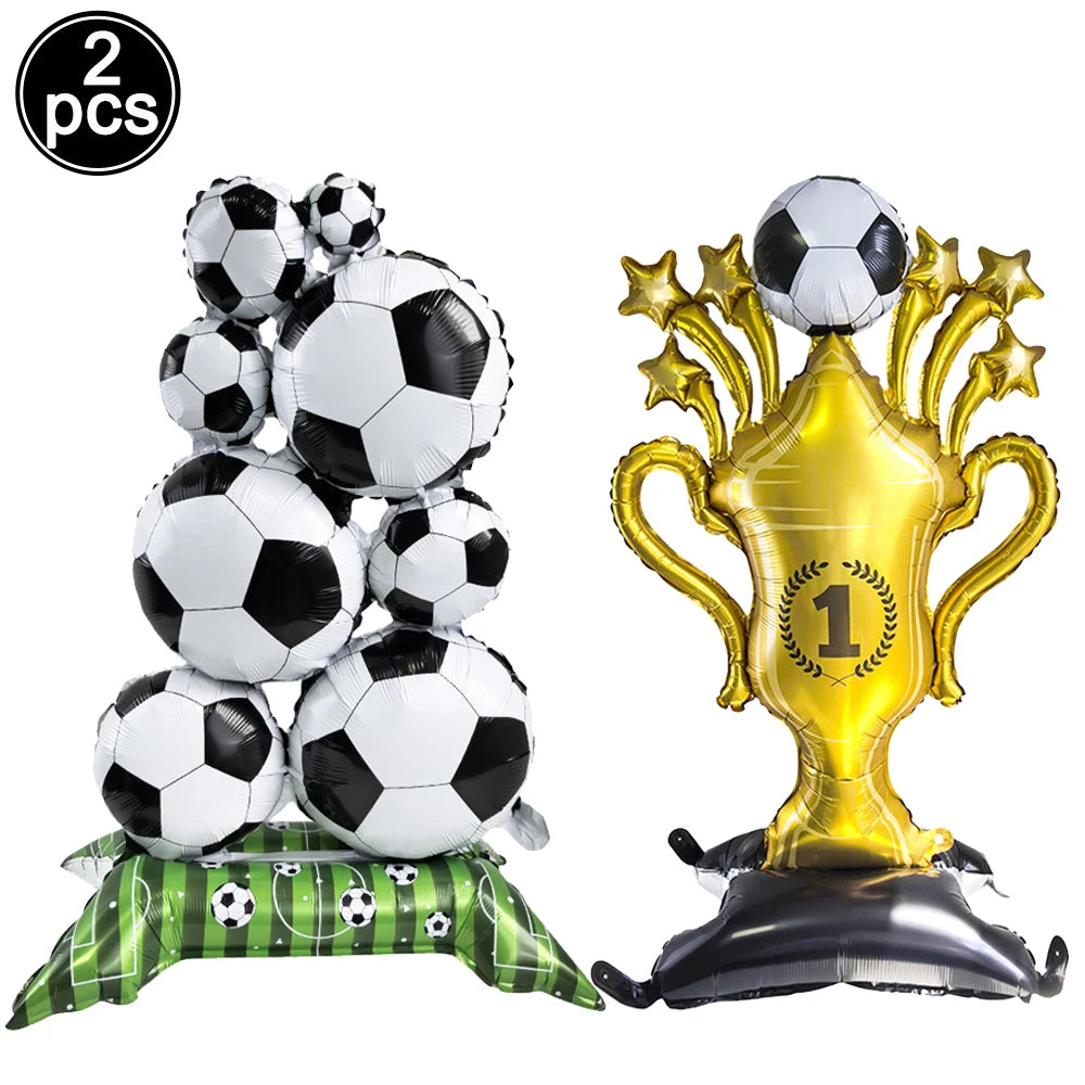 Two packs of white soccer balls and a gold trophy balloon for a football-themed party decor
