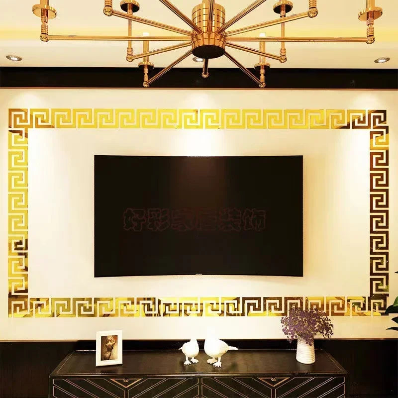 A rectangular black screen is framed by a gold decorative border on a wall, with a dark table in the foreground.