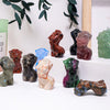 Colección de figuras de piedra de cuarzo rosa natural en varios colores y texturas, exhibidas sobre una superficie blanca.