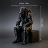 A dark sci-fi figurine of a hunter in armor is shown seated on a black pedestal.