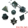 A set of seven green moss agate crystals in various geometric shapes including pyramids and spheres.