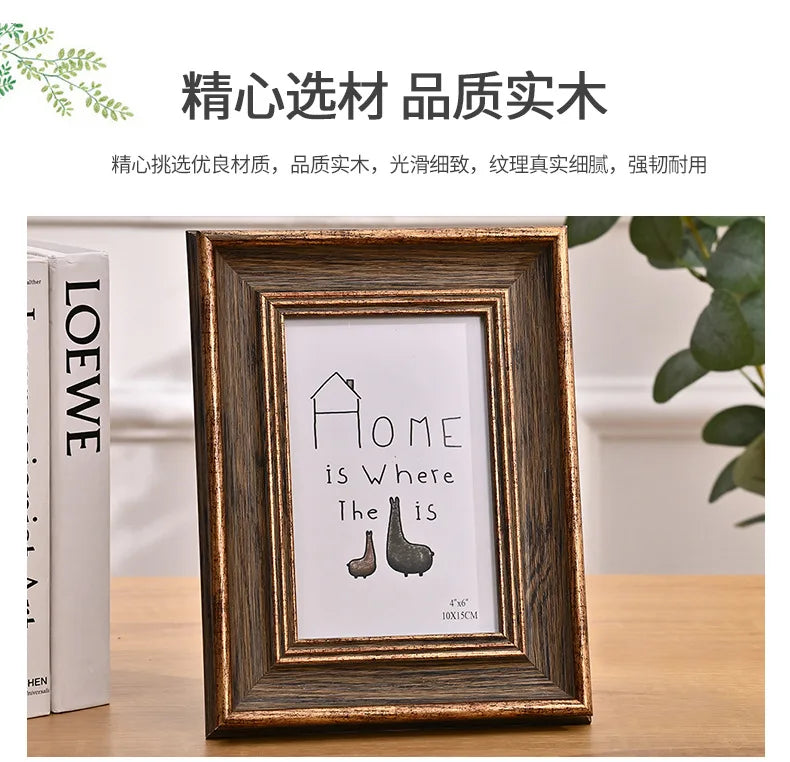 A wooden photo frame displaying the text Home is Where The Is, framed in dark wood.