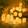 A collection of glowing white LED tea light candles in glass holders arranged on a wooden surface.