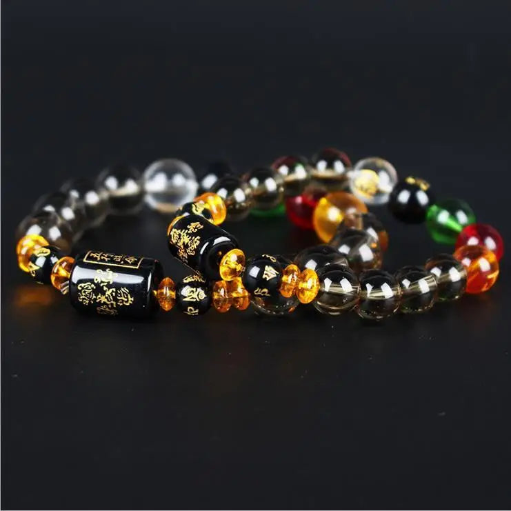 A bracelet made of various colored and translucent crystals, including amber, green, red, and black stones.