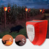 An orange solar-powered motion sensor alarm with a flashing siren is shown outdoors near cornfield plants.