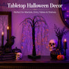 A decorative Halloween lighted willow tree with purple and orange LEDs displayed on a dark wooden surface.