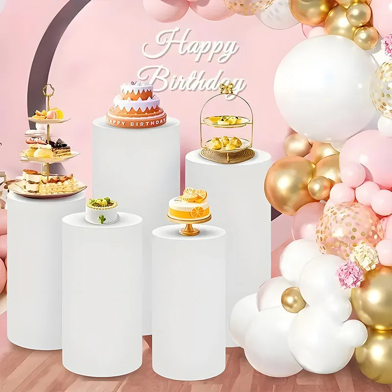 White elastic cylinder stands used as decorative display holders for birthday party items and balloons