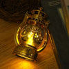 A brass LED lantern night light with a warm glow and decorative elements, resting on a wooden surface.