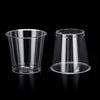 A clear plastic shot glass is shown on a black background.
