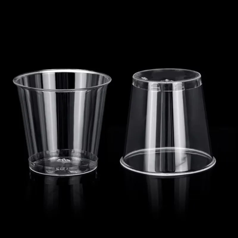 A clear plastic shot glass is shown on a black background.