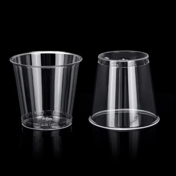 A clear plastic shot glass is shown on a black background.