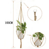 Handmade macrame plant hanger with a woven rope and a potted green plant hanging from a wooden rod.