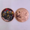 A gold-colored challenge coin featuring a grim reaper design with a skull and pirate theme.