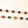 A set of colorful crystal waist chains featuring various colored gemstones like ruby, emerald, and sapphire.