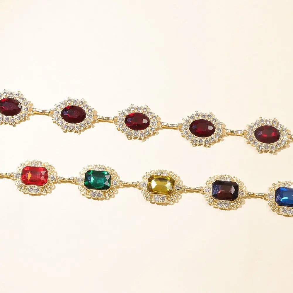 A set of colorful crystal waist chains featuring various colored gemstones like ruby, emerald, and sapphire.