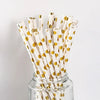 A glass jar filled with disposable party straws decorated with gold polka dots.