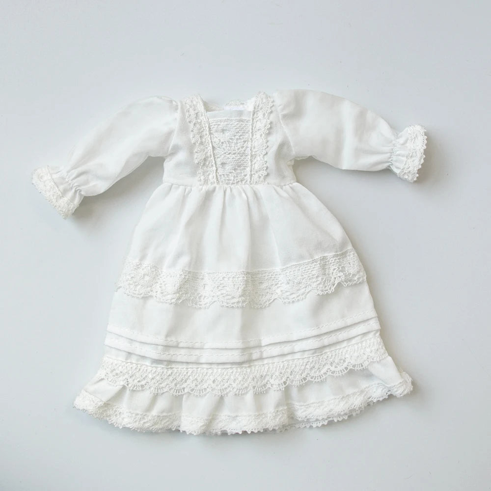 White vintage lace pajama set for a doll featuring ruffled sleeves and tiered skirt