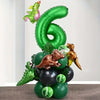 A green foil balloon set shaped like the number six and various dinosaur-themed balloons for a birthday party.
