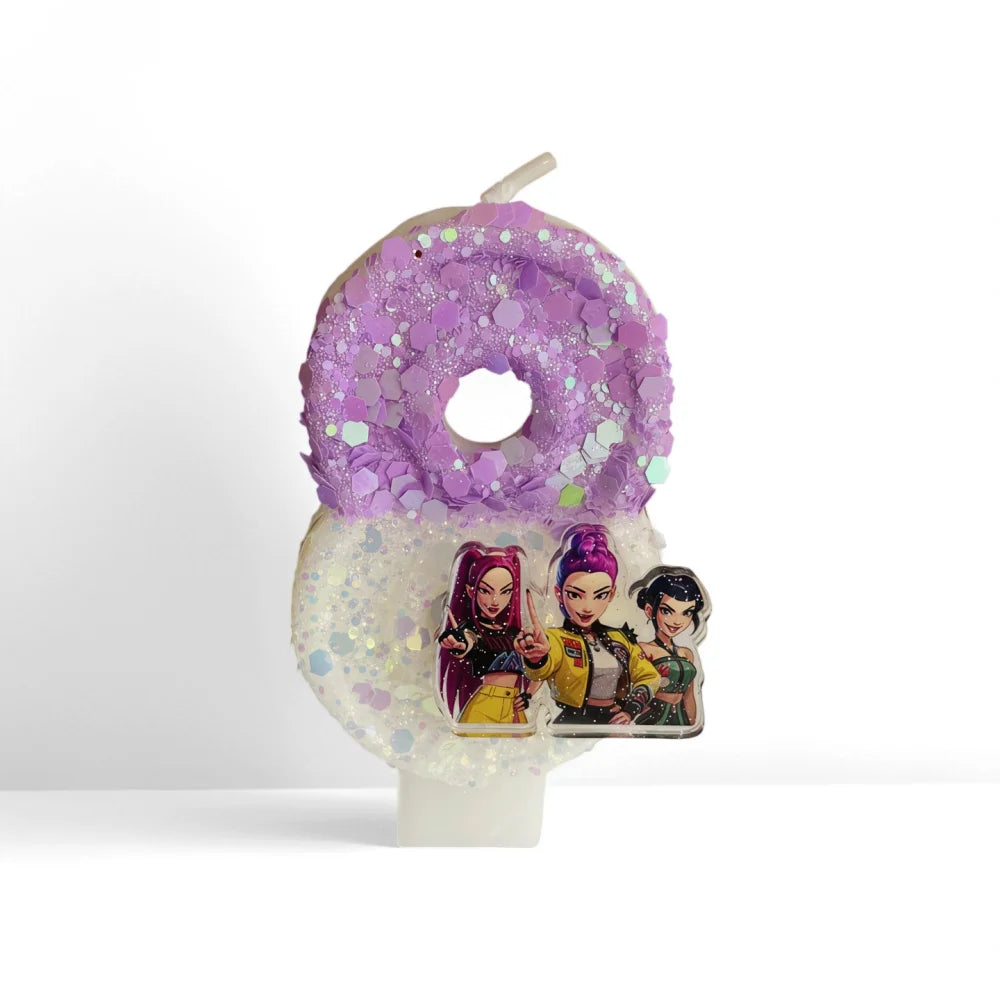 A purple glitter birthday candle shaped like a donut with three character figurines on the base.