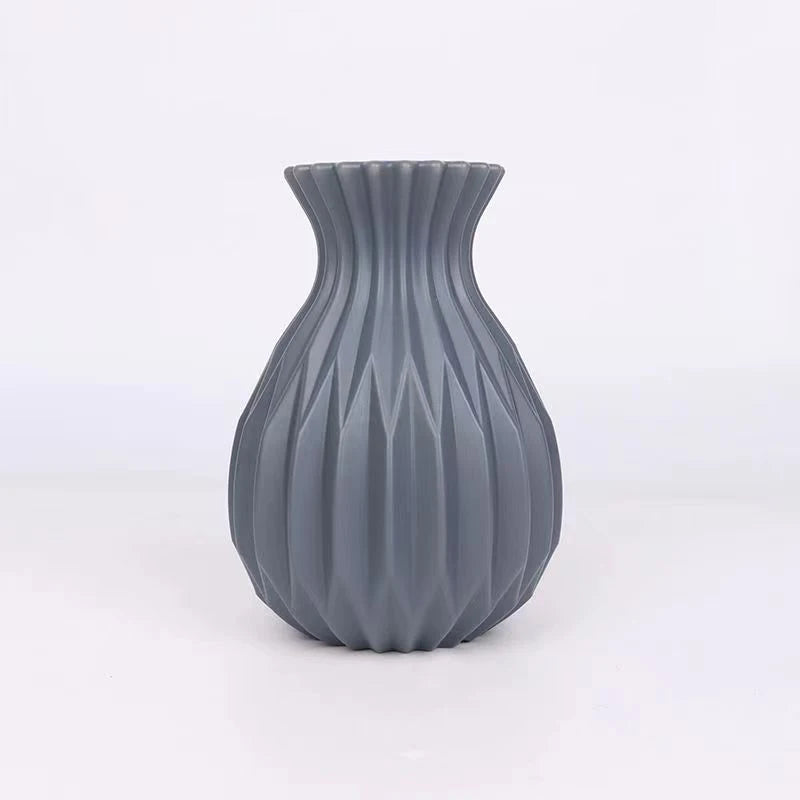A gray ceramic flower vase with vertical ribbed texture and a flared rim.