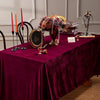 Burgundy red velvet rectangular tablecloth set for elegant dining featuring candles and decorative items