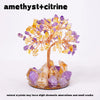 A crystal tree featuring amethyst and citrine crystals on a stand.