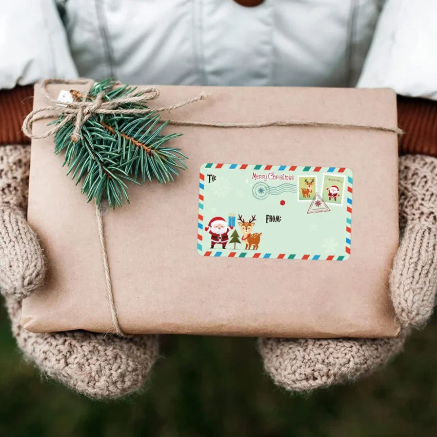 A brown gift box tied with twine and a green sprig, featuring Christmas-themed tags.