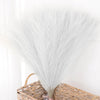 Un paquete de hierba de pampas artificial, esponjosa y plateada, para decoración del hogar.