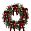 A green fir wreath decorated with red berries and velvet Christmas bows.