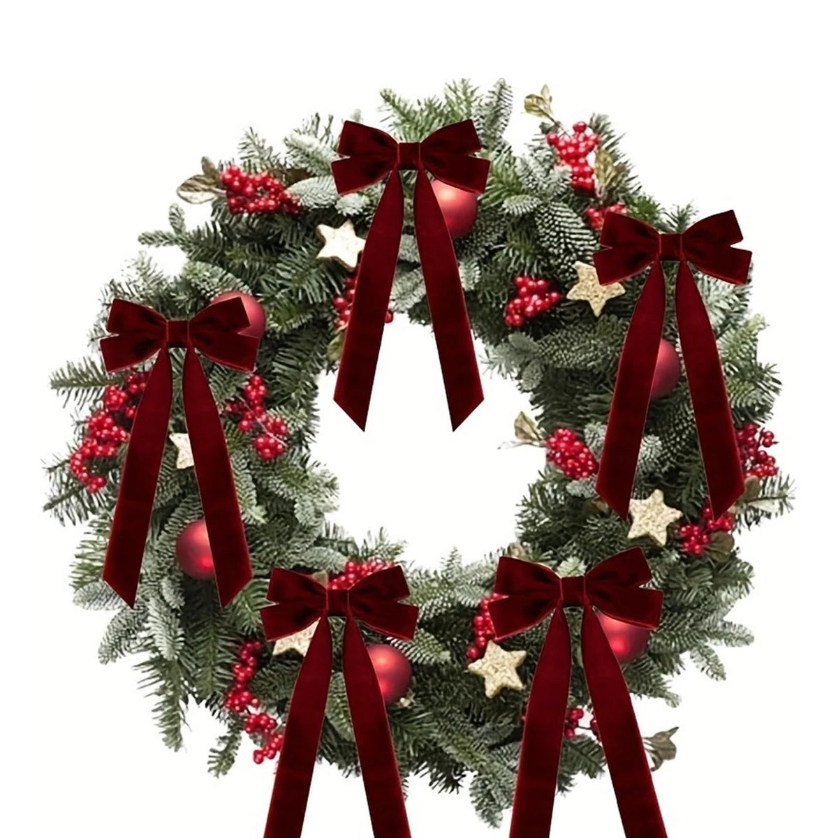 A green fir wreath decorated with red berries and velvet Christmas bows.