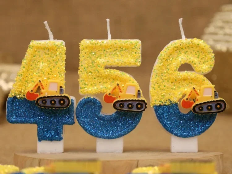 Three yellow and blue construction excavator birthday cake candles standing upright.
