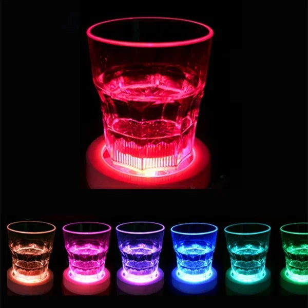 A row of luminous LED coasters showing various colors including red, pink, purple, blue, and green light patterns.