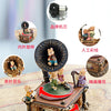 A detailed brass music box decoration featuring a carousel theme with figurines and intricate detailing.