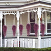 Purple silk morning glory vine hanging flowers decorating a white porch railing