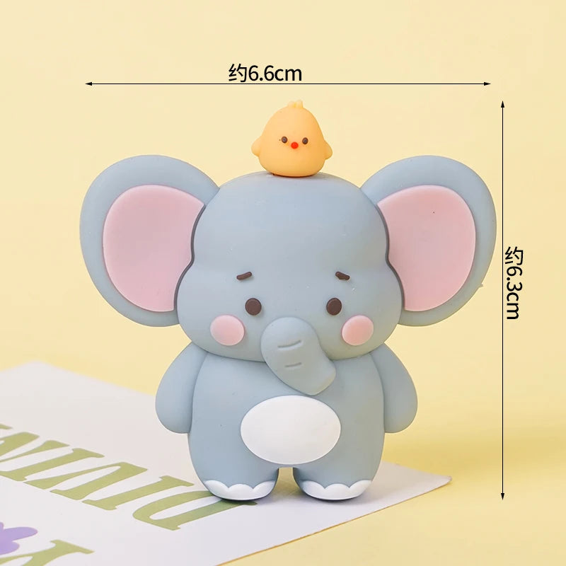 A cute light blue elephant cake topper with large ears and a small yellow chick, shown against a white background.