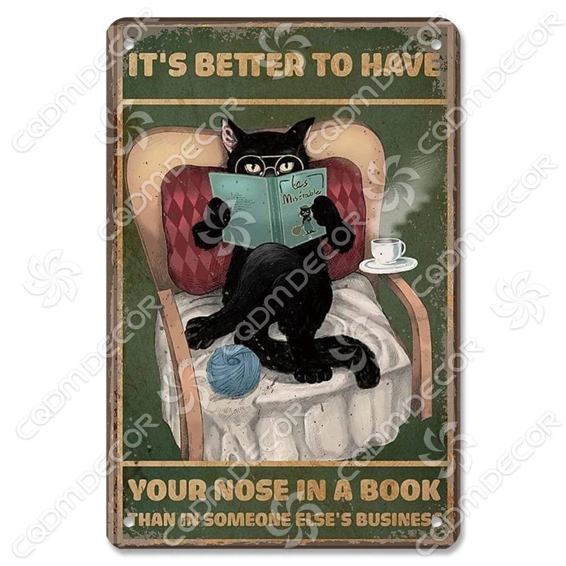 Décor mural vintage en métal représentant un chat noir assis dans un fauteuil à lire un livre