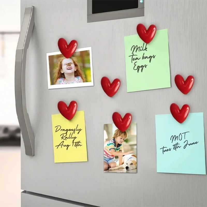 A collection of heart-shaped fridge magnets featuring various messages and images on colorful paper